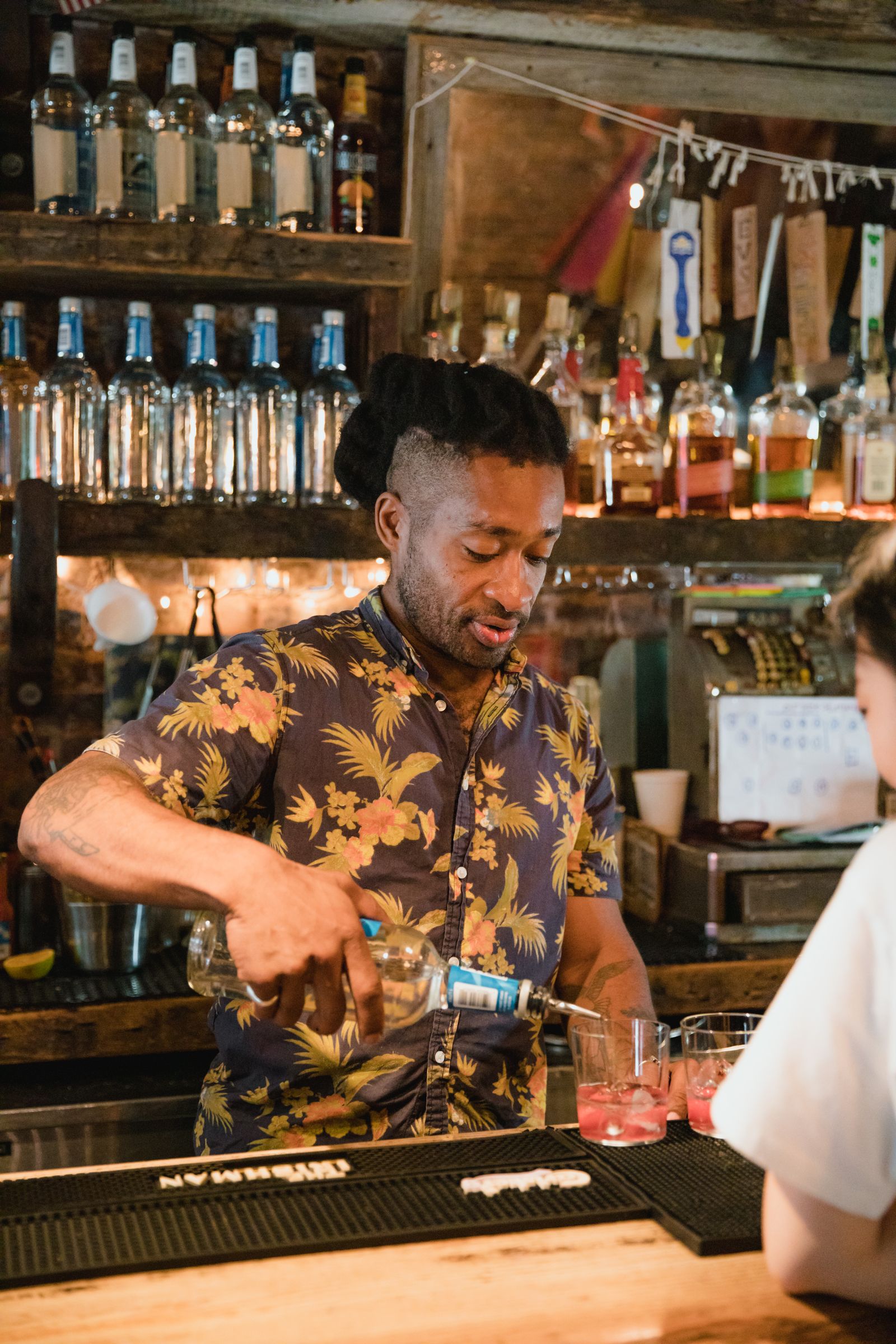 Bartender preparing drinks behind a busy bar