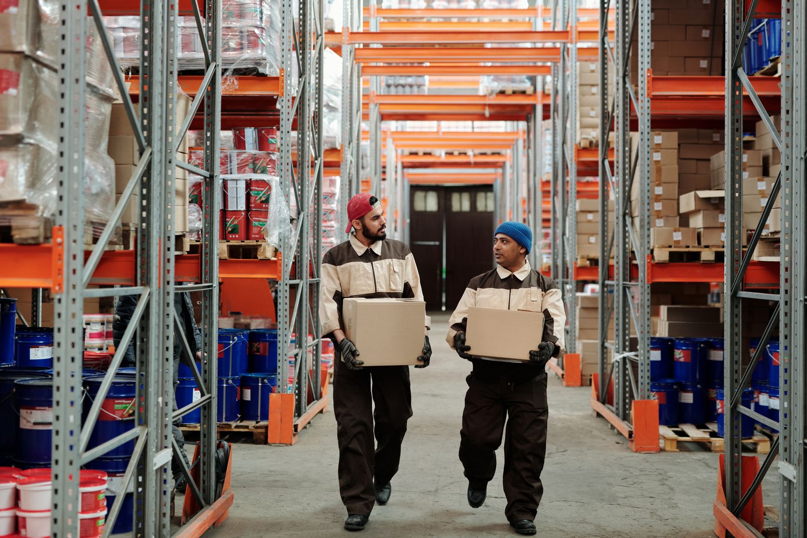Two warehouse workers carrying packages